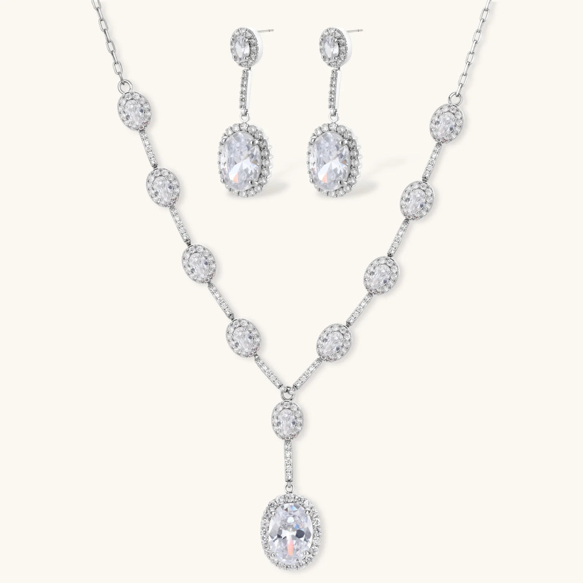 Elegant white gold plated jewelry set with oval cubic zirconia stones in halo settings, featuring Y-necklace and drop earrings.