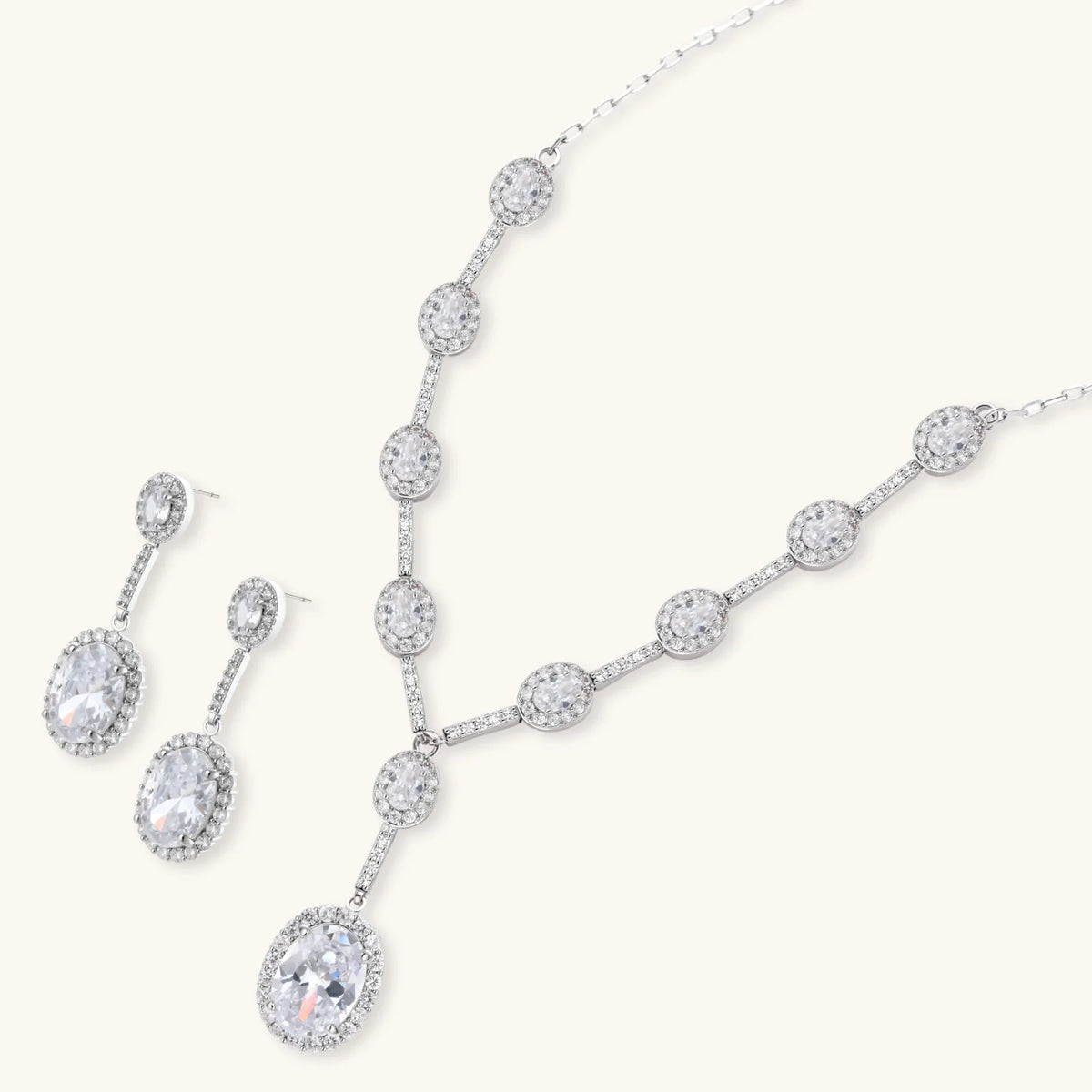 Elegant white gold plated jewelry set with oval cubic zirconia stones in halo settings, featuring Y-necklace and drop earrings.