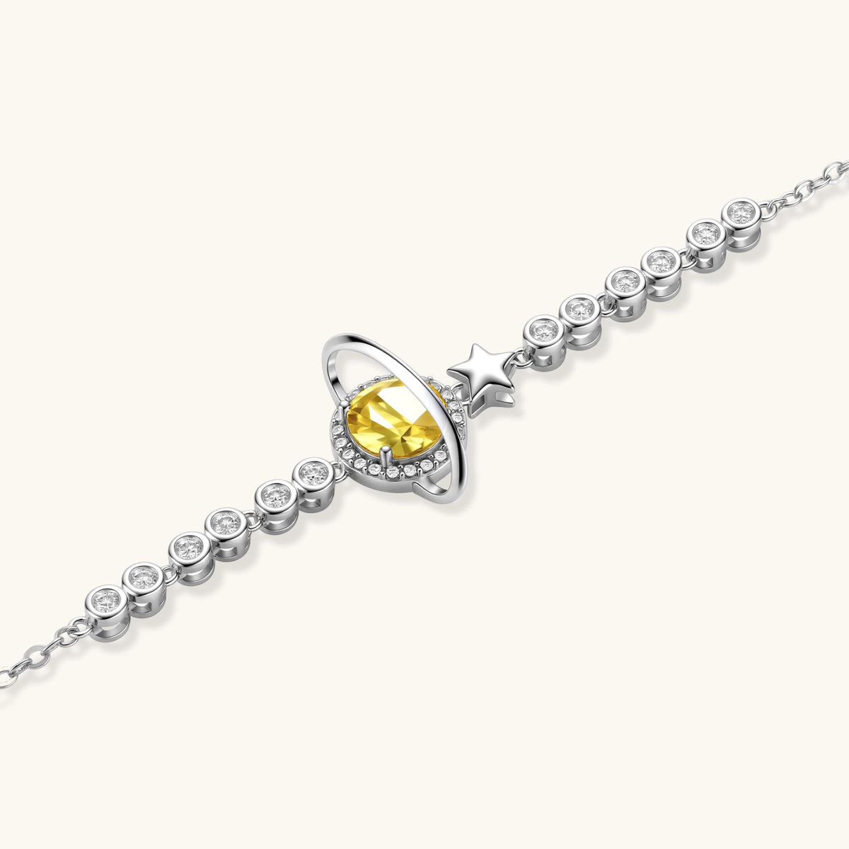 Sterling silver bracelet with yellow moissanite centerpiece in oval setting, crystal chain, and star charm on white background.