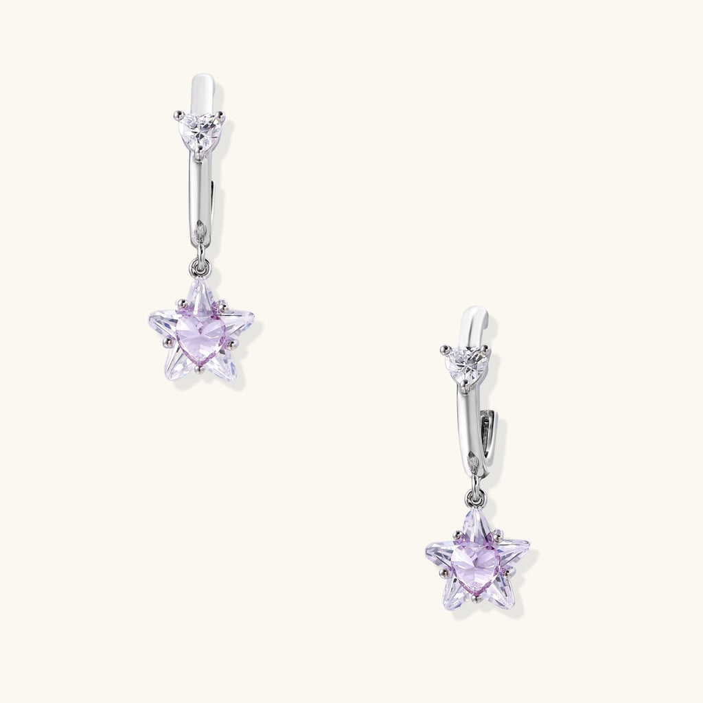 White gold plated huggie earrings with clear CZ accents and dangling lavender star-shaped crystals on cream background