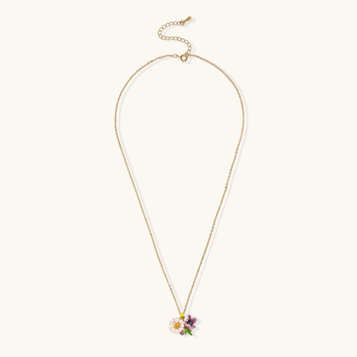 Gold-plated necklace with pink and purple enamel flower pendant featuring crystal accents on cream background