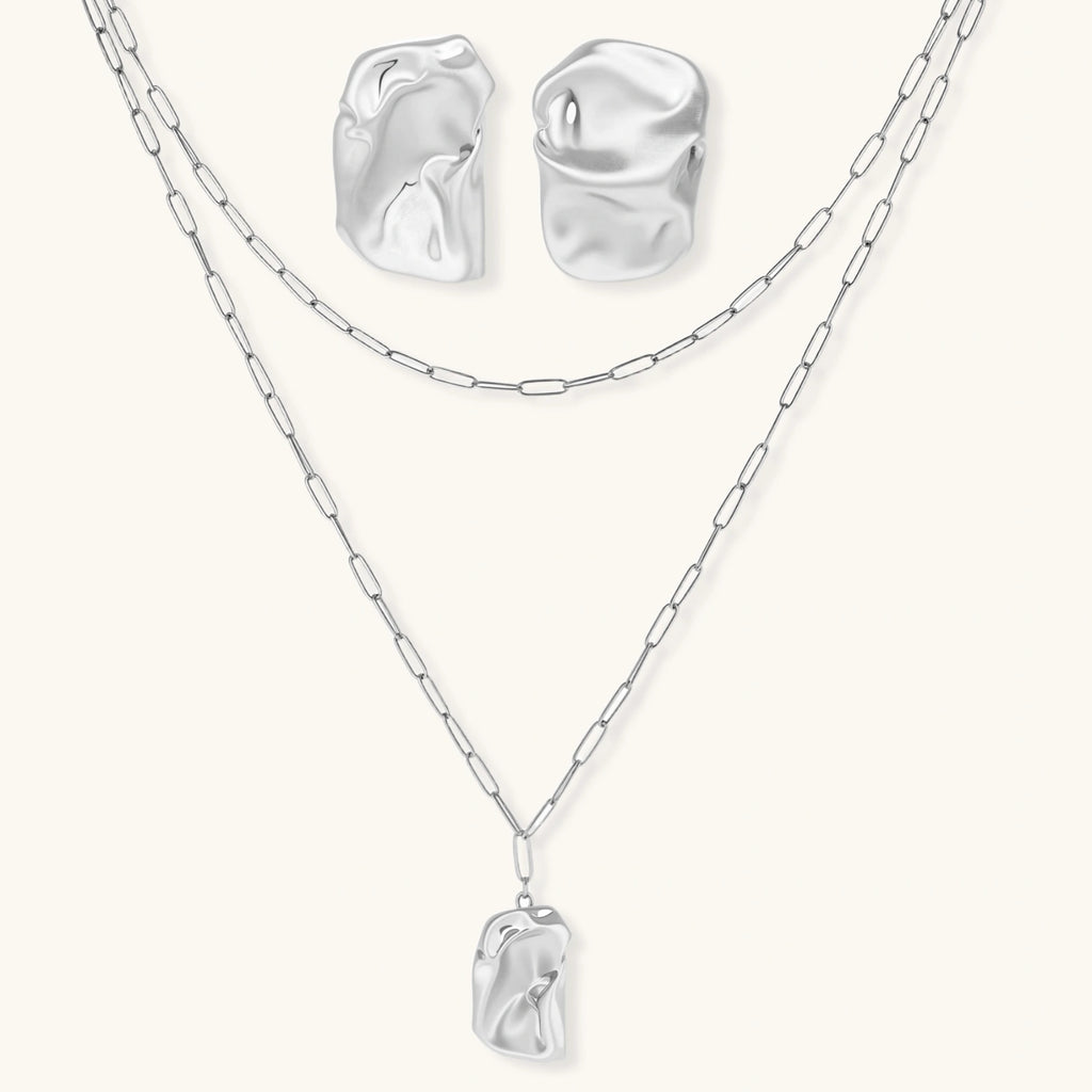 Modern textured hoop earrings and layered chain necklace with liquid metal pendant in silver and gold finishes.